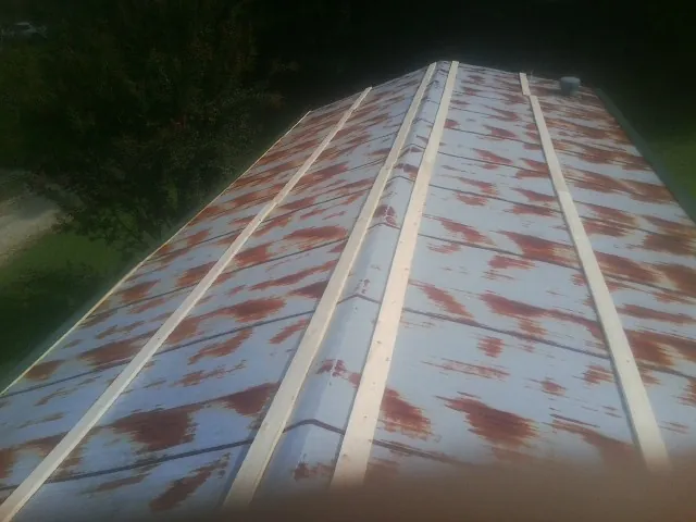 Rusted metal roof panels with new wood purlins before replacement — Storm Damage Roof Repair in Pricedale by Roofing Brothers