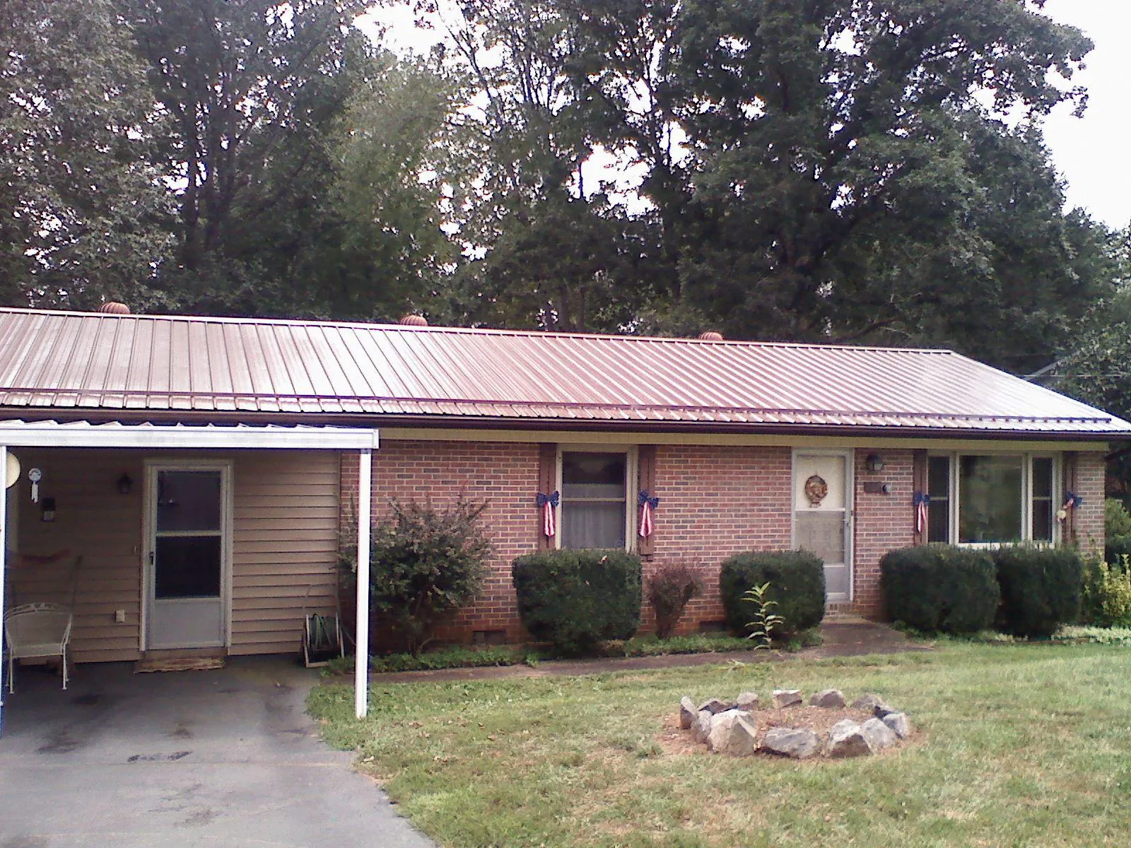 Bronze metal roof and carport on a brick ranch home — Roof Repair work by our crew in Pricedale